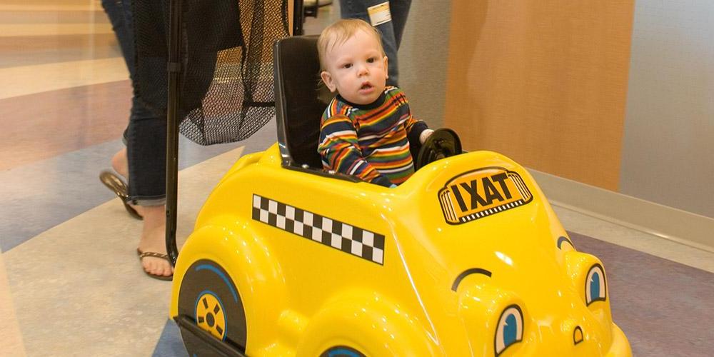 young patient in toy car