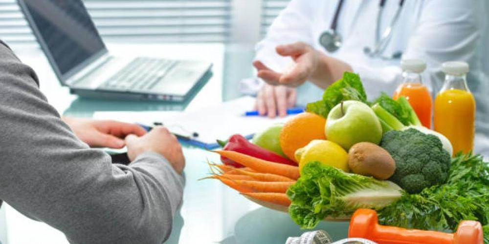 doctor speaking with patient with a pile of food on the table between them